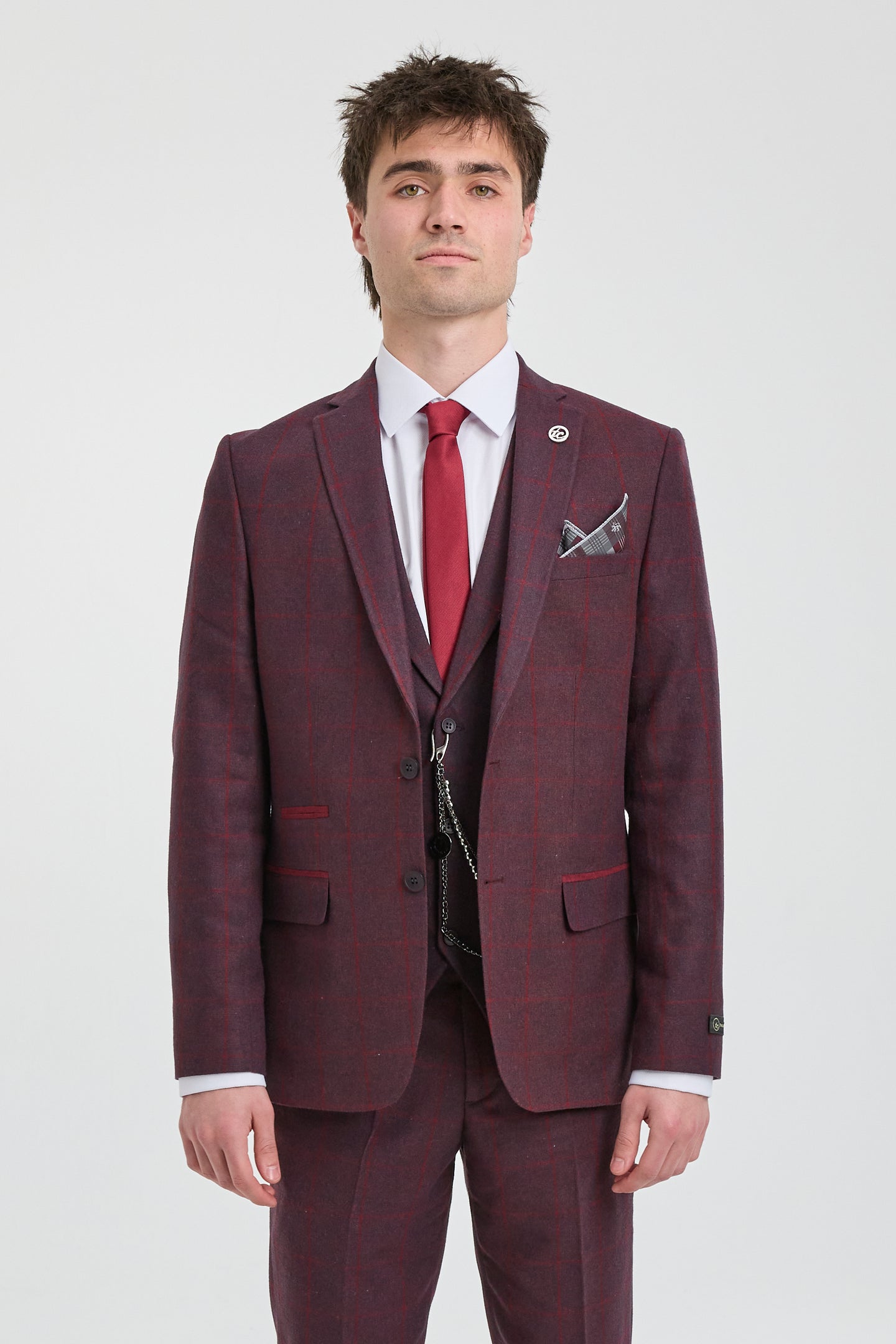 Man wearing a burgundy suit with a red tie on a white background