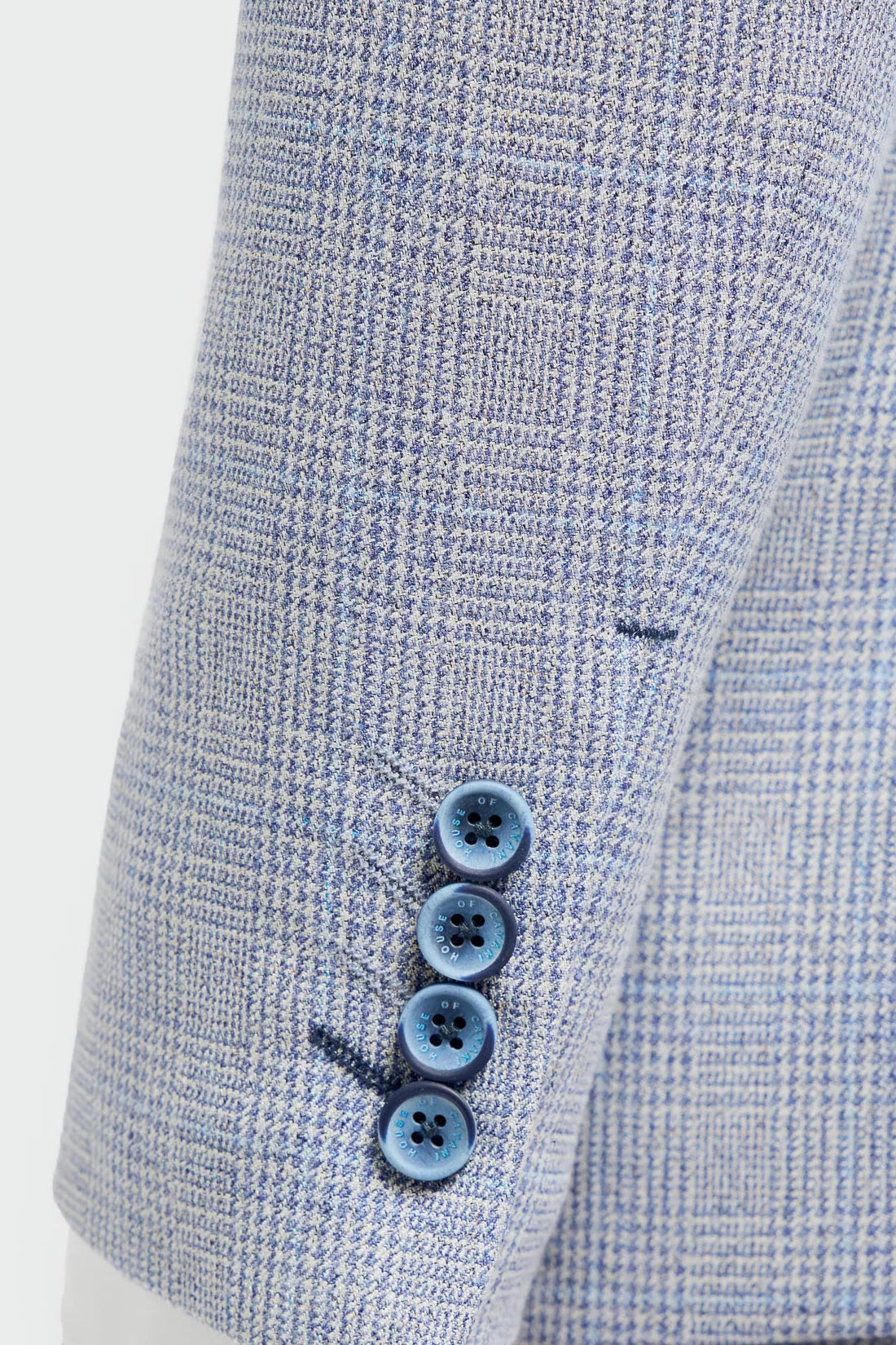 Close-up of a light blue checkered suit with three buttons on a white background
