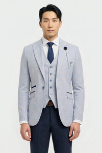 Man wearing a light gray blazer, navy vest, and dark blue tie on a white background