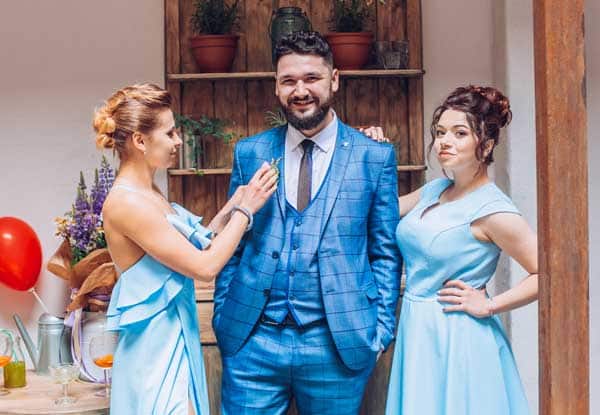 Groom in 3 piece wedding suit with bridesmaids on the wedding day, indoors | Happy Gentleman Groom in 3 piece wedding suit with bridesmaids on wedding day, indoors Happy Gentleman