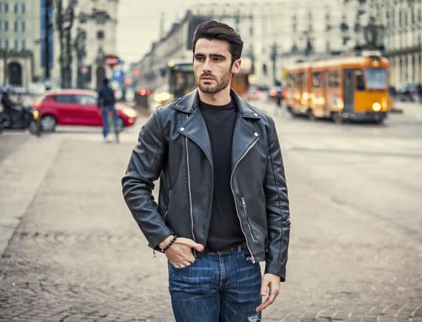 One handsome young man in urban setting in modern city wearing mens biker leather jacket and jeans HappyGentleman